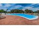 Large outdoor community pool with palm trees and ample lounge chairs for residents at 9607 Brassie Ct # 9607, New Port Richey, FL 34655