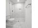 Modern bathroom featuring a tiled shower with glass door, a toilet, and white floors at 10006 Memorial Hwy, Tampa, FL 33615