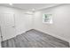 Bright bedroom with wood-look flooring, white walls, window, and closet at 10006 Memorial Hwy, Tampa, FL 33615