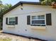 Side exterior of home featuring updated windows with decorative shutters and flower boxes at 10006 Memorial Hwy, Tampa, FL 33615