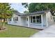 Charming home featuring a covered porch, fresh exterior paint and updated windows with decorative shutters at 10006 Memorial Hwy, Tampa, FL 33615