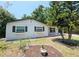 Charming home featuring a well-maintained front yard, fresh exterior paint and updated windows with decorative shutters at 10006 Memorial Hwy, Tampa, FL 33615
