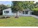 Charming home featuring a well-maintained front yard, fresh exterior paint and updated windows with decorative shutters at 10006 Memorial Hwy, Tampa, FL 33615