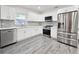 Modern kitchen featuring new floors, white cabinets, stone countertops and stainless steel appliances at 10006 Memorial Hwy, Tampa, FL 33615
