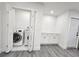 Bright laundry room featuring a modern washer and dryer, with stylish gray floors and ample storage space at 10006 Memorial Hwy, Tampa, FL 33615