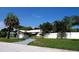 Landscaped front yard showcasing a single-story home with a white fence, offering privacy and curb appeal at 101 S Maywood Ave, Clearwater, FL 33765