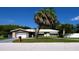 Charming single-story home with a well-manicured lawn and mature palm trees under a sunny blue sky at 101 S Maywood Ave, Clearwater, FL 33765