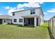 Expansive backyard featuring a screened lanai, green grass, and privacy fence at 10379 Bridgegate Heights Loop, San Antonio, FL 33576