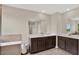 Bathroom featuring double sink vanity, large tub, and large mirror creating a bright and airy space at 10379 Bridgegate Heights Loop, San Antonio, FL 33576