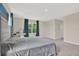 Bedroom featuring plush carpet, ensuite bathroom, and large sunny windows with green outside view at 10379 Bridgegate Heights Loop, San Antonio, FL 33576