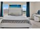 Bright bedroom with large windows, beach artwork, and a stylish upholstered headboard at 10379 Bridgegate Heights Loop, San Antonio, FL 33576
