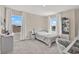Bright bedroom featuring two large windows, a bed, and a desk at 10379 Bridgegate Heights Loop, San Antonio, FL 33576
