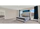 Spacious bedroom featuring plush gray carpet, a large picture window, and modern decor at 10379 Bridgegate Heights Loop, San Antonio, FL 33576