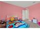 Bright bedroom with pink walls, plush toys, and patterned comforter at 10379 Bridgegate Heights Loop, San Antonio, FL 33576