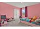 bedroom with pink walls featuring a colorful cartoon-themed bed and window at 10379 Bridgegate Heights Loop, San Antonio, FL 33576