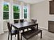 Cozy dining area with wooden table and bench seating, and a view of the green backyard at 10379 Bridgegate Heights Loop, San Antonio, FL 33576
