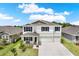 Charming two-story home featuring a three-car garage, a covered porch, and manicured landscaping at 10379 Bridgegate Heights Loop, San Antonio, FL 33576