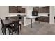 Bright kitchen with stainless steel appliances, dark wood cabinets and a large kitchen island at 10379 Bridgegate Heights Loop, San Antonio, FL 33576