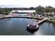 Expansive aerial view of lakeside clubhouse featuring a pool and fishing pier at 10520 Tapestry Dr, Port Richey, FL 34668