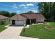 Home with a well-kept lawn, a welcoming porch, and an attached garage at 10520 Tapestry Dr, Port Richey, FL 34668