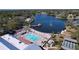 Community aerial view showing a sparkling pool, shuffleboard courts, a pier and lake at 10520 Tapestry Dr, Port Richey, FL 34668