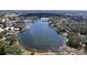 Aerial view of a serene lake in a neighborhood with lush trees and well-maintained homes at 10520 Tapestry Dr, Port Richey, FL 34668