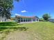 Expansive backyard featuring lush green grass, a screen enclosed patio, and plenty of space for outdoor activities at 10520 Tapestry Dr, Port Richey, FL 34668