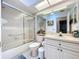 Well-lit bathroom with a glass shower, toilet, and vanity with storage at 10520 Tapestry Dr, Port Richey, FL 34668