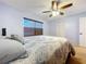 Cozy bedroom with a plush bed, ceiling fan, window and a closet with bi-fold doors at 10520 Tapestry Dr, Port Richey, FL 34668