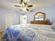 Bedroom features a wooden dresser, closet, ceiling fan and neutral carpet at 10520 Tapestry Dr, Port Richey, FL 34668