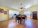 Inviting dining area with wood floors, vaulted ceiling, and natural light from large windows at 10520 Tapestry Dr, Port Richey, FL 34668