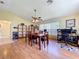 Bright dining room showcasing wood floors, table with chairs, and access to a home office area at 10520 Tapestry Dr, Port Richey, FL 34668
