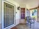 Inviting front porch with decorative columns, window, seating area, and secure front door at 10520 Tapestry Dr, Port Richey, FL 34668