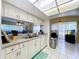 Kitchen with white cabinets, stainless steel sink and appliances, adjacent to eating area at 10520 Tapestry Dr, Port Richey, FL 34668