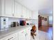 Bright kitchen with white cabinets, desk area, and view into the Gathering room at 10520 Tapestry Dr, Port Richey, FL 34668