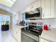 Updated kitchen features stainless steel oven, microwave, and white cabinets at 10520 Tapestry Dr, Port Richey, FL 34668