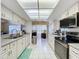 Bright kitchen featuring white cabinetry, stainless steel appliances, and tile flooring at 10520 Tapestry Dr, Port Richey, FL 34668