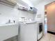 Laundry room features a sink, modern washer and dryer with overhead storage shelving at 10520 Tapestry Dr, Port Richey, FL 34668