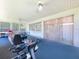 Bright sun room featuring light walls, blue carpet and workout equipment for wellness and recreation at 10520 Tapestry Dr, Port Richey, FL 34668