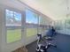 Sunroom with large windows overlooking a lawn, exercise equipment and a welcome mat by the door at 10520 Tapestry Dr, Port Richey, FL 34668
