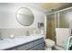 Updated bathroom with large round mirror, shower stall, and modern fixtures at 11200 102Nd Ave # 62, Seminole, FL 33778