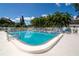 Community swimming pool with a safety fence and ladder entry, surrounded by palm trees at 11200 102Nd Ave # 62, Seminole, FL 33778