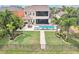 Aerial view of home's backyard featuring a pool, lush green lawn, and beautifully landscaped gardens at 11327 Lake Lucaya Dr, Riverview, FL 33579