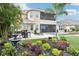 Lush backyard with colorful flowerbeds, palm trees, fountain, and outdoor seating at 11327 Lake Lucaya Dr, Riverview, FL 33579