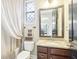 Well-lit bathroom featuring a granite-topped vanity, window, and white curtains that add to the serene atmosphere at 11327 Lake Lucaya Dr, Riverview, FL 33579