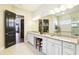 Bathroom with double sinks, granite countertops and white cabinetry at 11327 Lake Lucaya Dr, Riverview, FL 33579