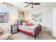 Cozy bedroom with a colorful comforter, window, and decorative wall art creating a bright and inviting space at 11327 Lake Lucaya Dr, Riverview, FL 33579