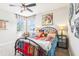 Cozy bedroom with a colorful comforter, window, and decorative wall art creating a bright and inviting space at 11327 Lake Lucaya Dr, Riverview, FL 33579