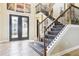 Grand foyer with decorative glass front door and a staircase featuring iron and wood detailing at 11327 Lake Lucaya Dr, Riverview, FL 33579