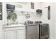 Well-organized laundry room with modern washer and dryer, sink, and ample shelving at 11327 Lake Lucaya Dr, Riverview, FL 33579